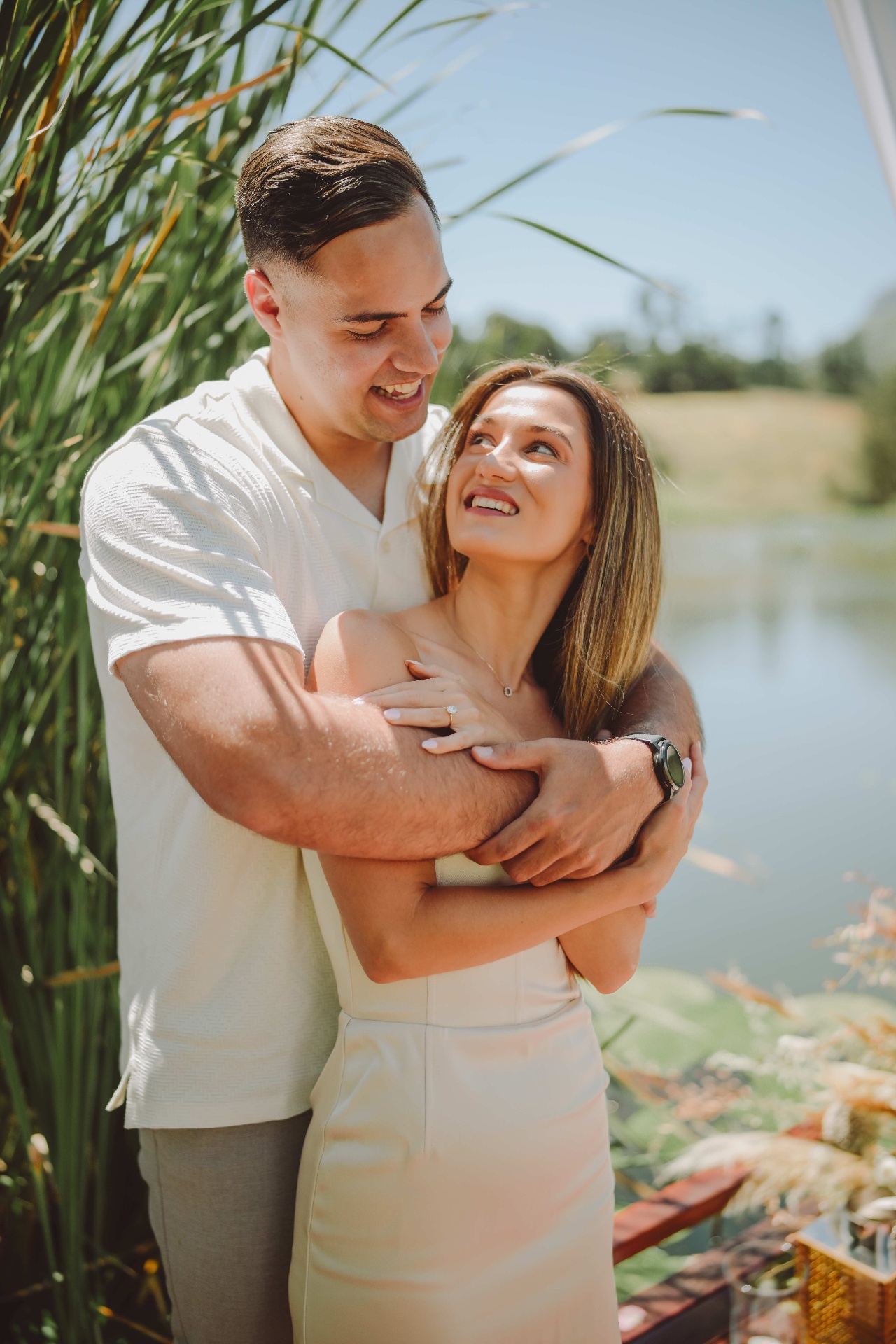 Byron and Inge embracing by the water